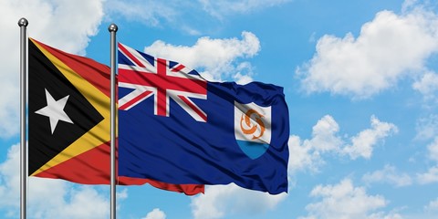 East Timor and Anguilla flag waving in the wind against white cloudy blue sky together. Diplomacy...