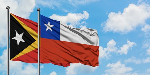 East Timor and Chile flag waving in the wind against white cloudy blue sky together. Diplomacy concept, international relations.
