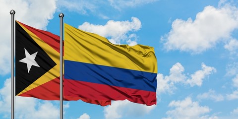 East Timor and Colombia flag waving in the wind against white cloudy blue sky together. Diplomacy concept, international relations.