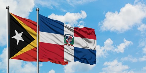 East Timor and Dominican Republic flag waving in the wind against white cloudy blue sky together. Diplomacy concept, international relations.