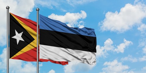 East Timor and Estonia flag waving in the wind against white cloudy blue sky together. Diplomacy concept, international relations.