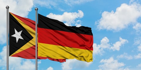 East Timor and Germany flag waving in the wind against white cloudy blue sky together. Diplomacy concept, international relations.