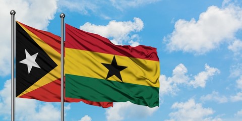 East Timor and Ghana flag waving in the wind against white cloudy blue sky together. Diplomacy concept, international relations.