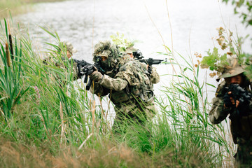 Soldiers in a combat situation. Men play airsoft.
