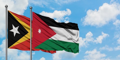 East Timor and Jordan flag waving in the wind against white cloudy blue sky together. Diplomacy concept, international relations.