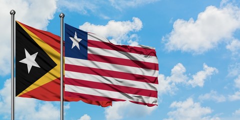 East Timor and Liberia flag waving in the wind against white cloudy blue sky together. Diplomacy concept, international relations.