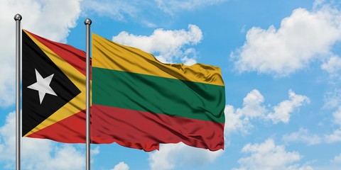 East Timor and Lithuania flag waving in the wind against white cloudy blue sky together. Diplomacy concept, international relations.