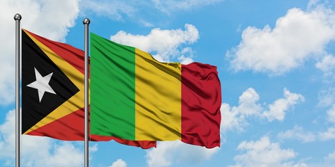 East Timor and Mali flag waving in the wind against white cloudy blue sky together. Diplomacy concept, international relations.