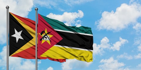 East Timor and Mozambique flag waving in the wind against white cloudy blue sky together. Diplomacy concept, international relations.
