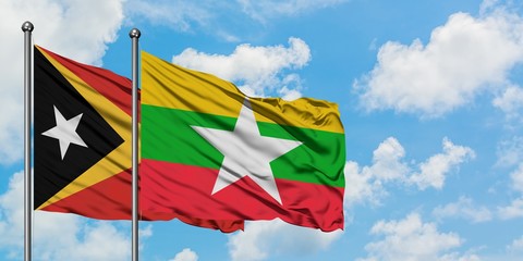 East Timor and Myanmar flag waving in the wind against white cloudy blue sky together. Diplomacy concept, international relations.
