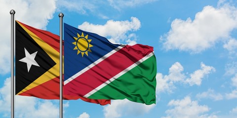 East Timor and Namibia flag waving in the wind against white cloudy blue sky together. Diplomacy concept, international relations.