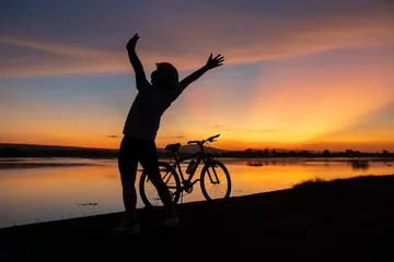 Foto op Plexiglas Happiness cyclist silhouette  cheerful with bicycle and sunset time © EmmaStock