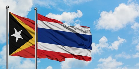 East Timor and Thailand flag waving in the wind against white cloudy blue sky together. Diplomacy concept, international relations.