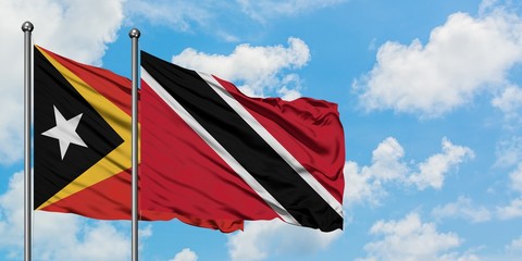 East Timor and Trinidad And Tobago flag waving in the wind against white cloudy blue sky together. Diplomacy concept, international relations.