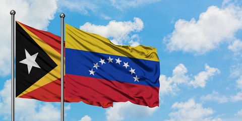 East Timor and Venezuela flag waving in the wind against white cloudy blue sky together. Diplomacy concept, international relations.