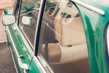 détail d'une vieille voiture verte avec le rétroviseur et le siège