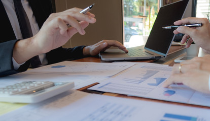 Businessmen, financial accountants, business planners, business planning ideas using computers, laptops, smat phones, and work calculators