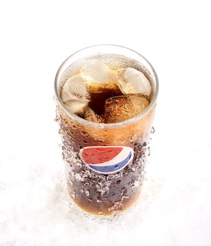 POLTAVA, UKRAINE - MARCH 22, 2018: Cold glass of Pepsi-Cola with ice on white background. Pepsi is a carbonated soft drink sold in stores, restaurants, and vending machines throughout the world.