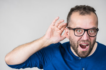 Man eavesdropping with hand close to ear