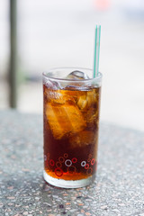 Cola in glass with ice on table