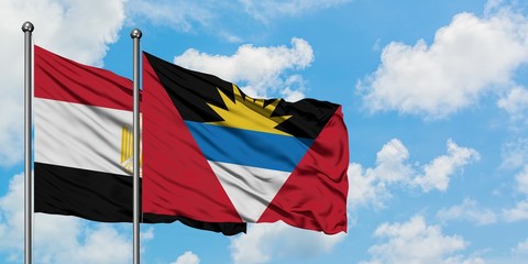 Egypt and Antigua and Barbuda flag waving in the wind against white cloudy blue sky together. Diplomacy concept, international relations.