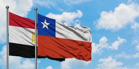 Egypt and Chile flag waving in the wind against white cloudy blue sky together. Diplomacy concept, international relations.