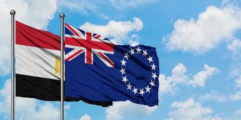 Egypt and Cook Islands flag waving in the wind against white cloudy blue sky together. Diplomacy...