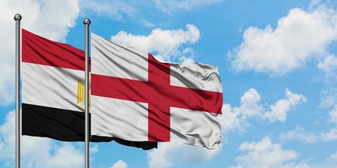 Egypt and England flag waving in the wind against white cloudy blue sky together. Diplomacy concept, international relations.