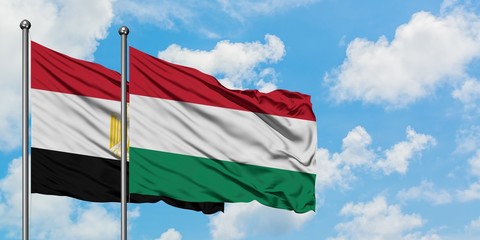 Egypt and Hungary flag waving in the wind against white cloudy blue sky together. Diplomacy concept, international relations.