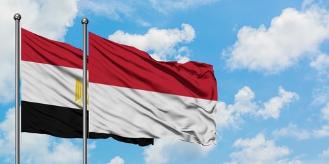 Egypt and Indonesia flag waving in the wind against white cloudy blue sky together. Diplomacy concept, international relations.