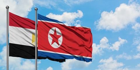 Egypt and North Korea flag waving in the wind against white cloudy blue sky together. Diplomacy concept, international relations.