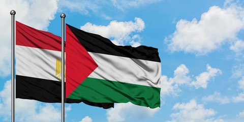 Egypt and Palestine flag waving in the wind against white cloudy blue sky together. Diplomacy concept, international relations.