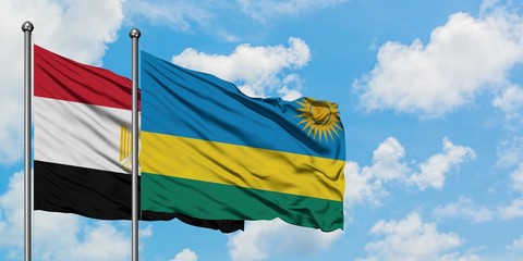 Egypt and Rwanda flag waving in the wind against white cloudy blue sky together. Diplomacy concept, international relations.
