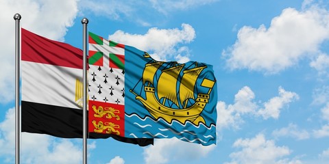 Egypt and Saint Pierre And Miquelon flag waving in the wind against white cloudy blue sky together. Diplomacy concept, international relations.