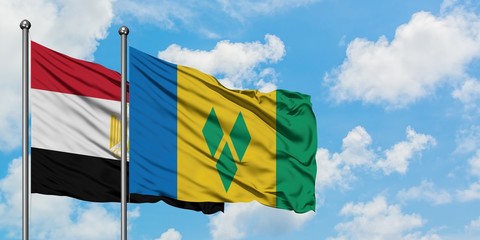 Egypt and Saint Vincent And The Grenadines flag waving in the wind against white cloudy blue sky together. Diplomacy concept, international relations.