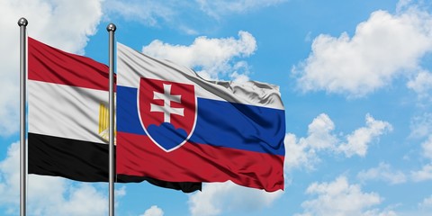 Egypt and Slovakia flag waving in the wind against white cloudy blue sky together. Diplomacy concept, international relations.