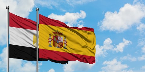 Egypt and Spain flag waving in the wind against white cloudy blue sky together. Diplomacy concept, international relations.