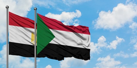 Egypt and Sudan flag waving in the wind against white cloudy blue sky together. Diplomacy concept, international relations.