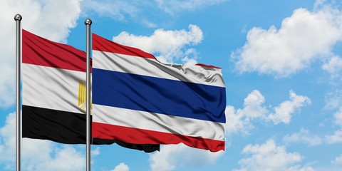 Egypt and Thailand flag waving in the wind against white cloudy blue sky together. Diplomacy concept, international relations.
