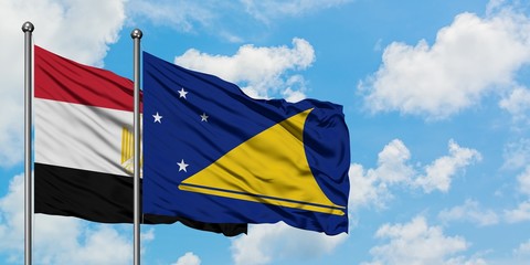 Egypt and Tokelau flag waving in the wind against white cloudy blue sky together. Diplomacy concept, international relations.