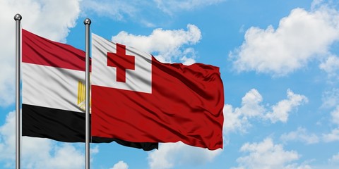 Egypt and Tonga flag waving in the wind against white cloudy blue sky together. Diplomacy concept, international relations.