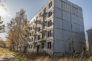 Fototapeta na wymiar Abandoned five-story concrete house in abandoned ghost town
