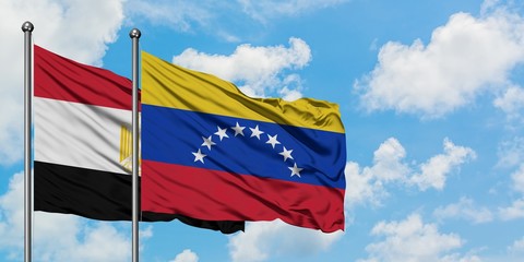 Egypt and Venezuela flag waving in the wind against white cloudy blue sky together. Diplomacy concept, international relations.