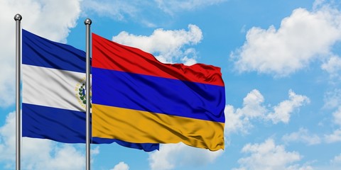 El Salvador and Armenia flag waving in the wind against white cloudy blue sky together. Diplomacy concept, international relations.