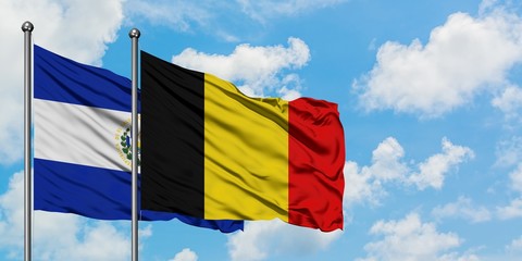 El Salvador and Belgium flag waving in the wind against white cloudy blue sky together. Diplomacy concept, international relations.