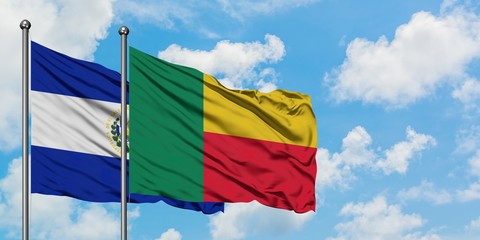 El Salvador and Benin flag waving in the wind against white cloudy blue sky together. Diplomacy concept, international relations.
