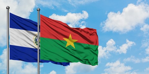 El Salvador and Burkina Faso flag waving in the wind against white cloudy blue sky together. Diplomacy concept, international relations.