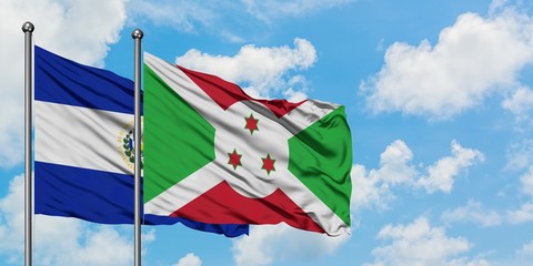 El Salvador and Burundi flag waving in the wind against white cloudy blue sky together. Diplomacy concept, international relations.