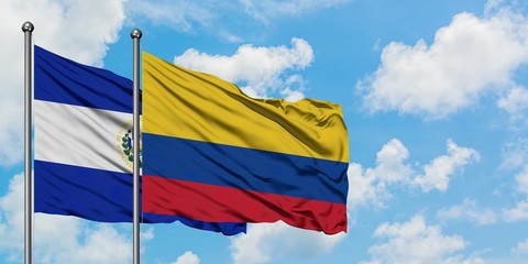 El Salvador and Colombia flag waving in the wind against white cloudy blue sky together. Diplomacy concept, international relations.
