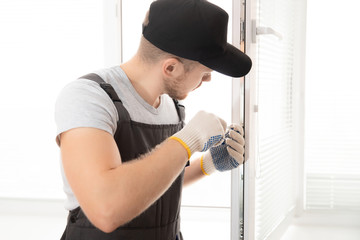 Construction worker man install plastic white upvc windows in house